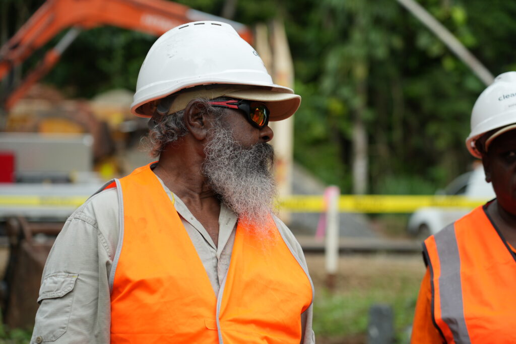 A photograph of a Djabugay Traditional Owner wearing high vis clothing and a hard hat