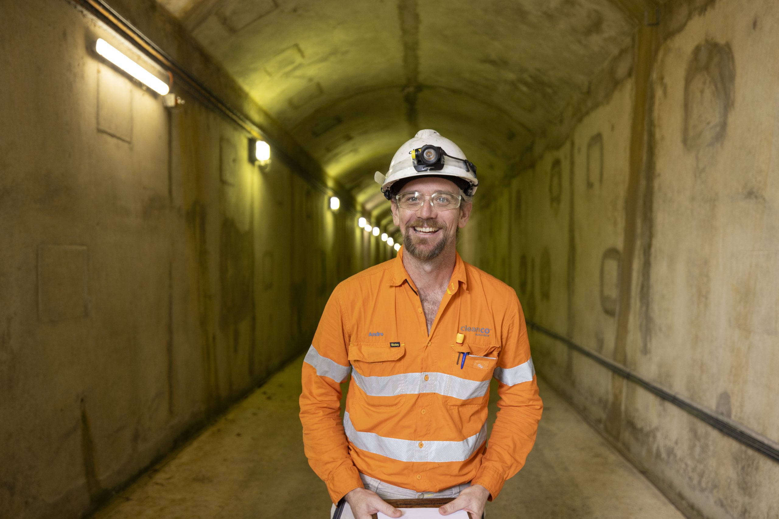 Photograph of a Barron Gorge Power Station worker in a tunnel, smiling at the camera