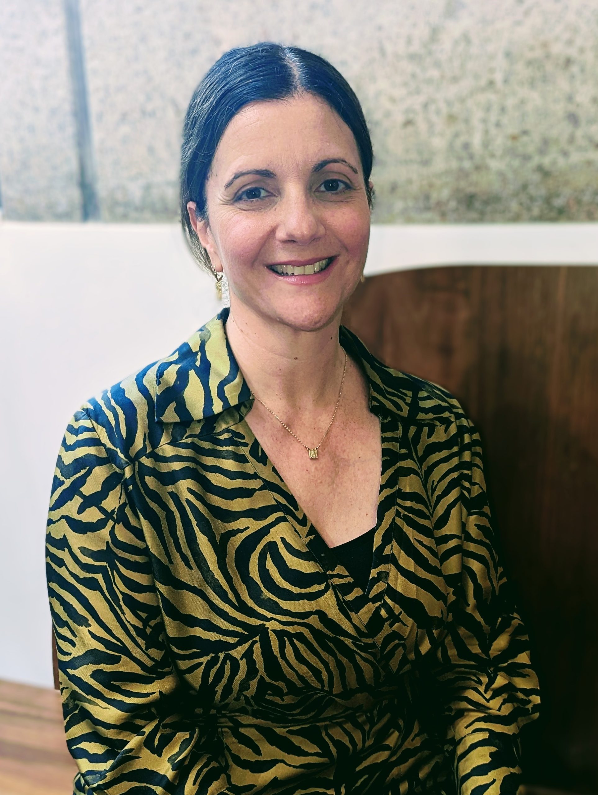 A CleanCo employee named Simona, sitting and smiling as she looks directly at the camera.