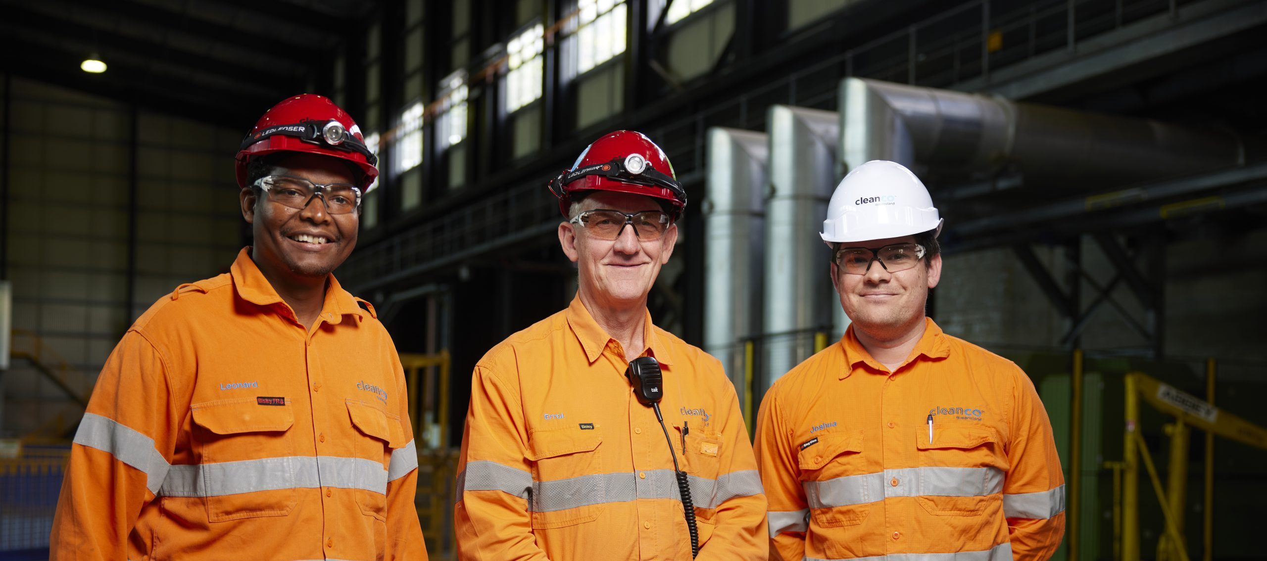 Three workers from Wivenhoe Power Station. They are smiling, wearing safety gear, and are in their CleanCo work attire.