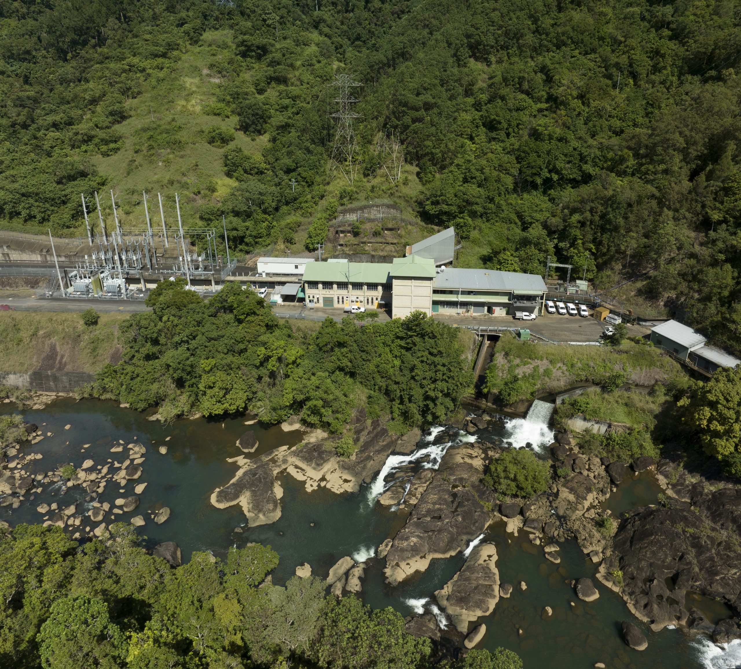 An aerial photograph of Kareeya Power Station on a sunny day. The Power Station is surrounded by lush greenery.